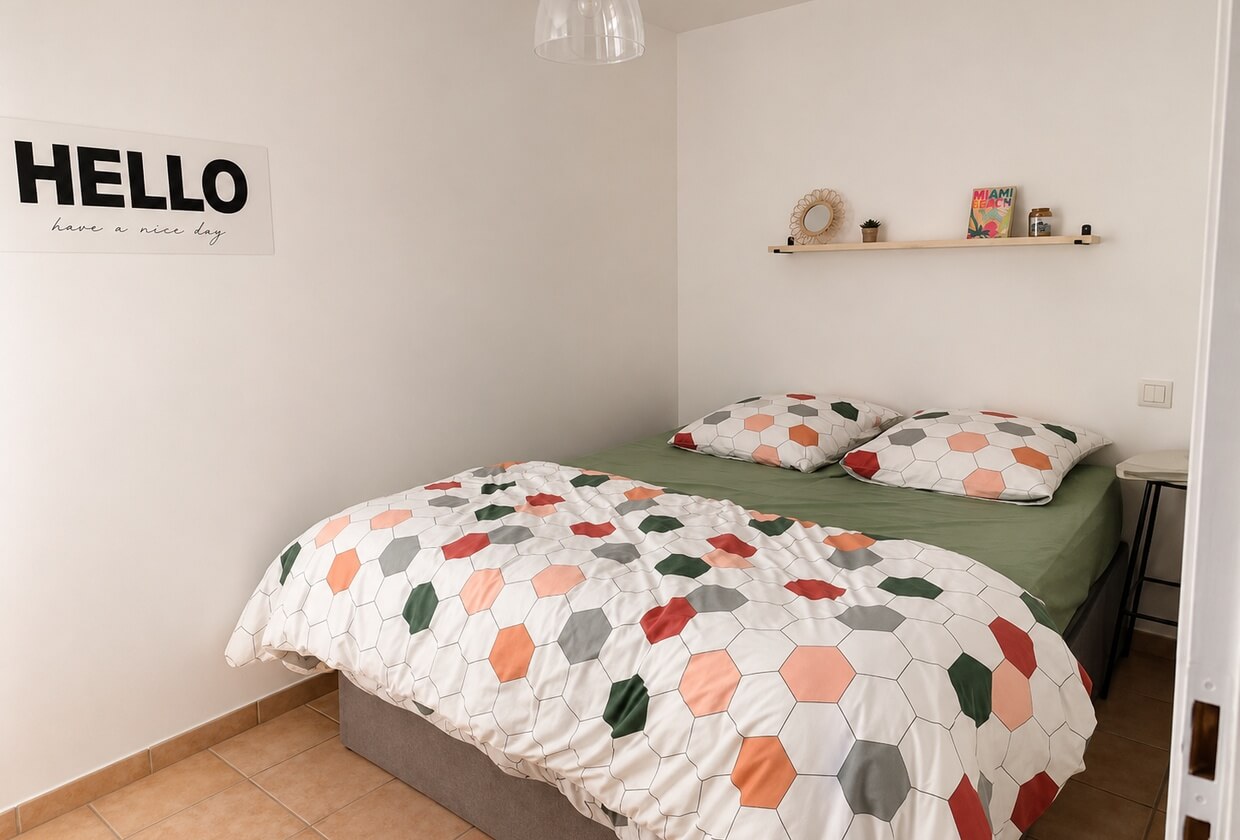 Chambre claire, lit double et affiche « Hello » au mur
