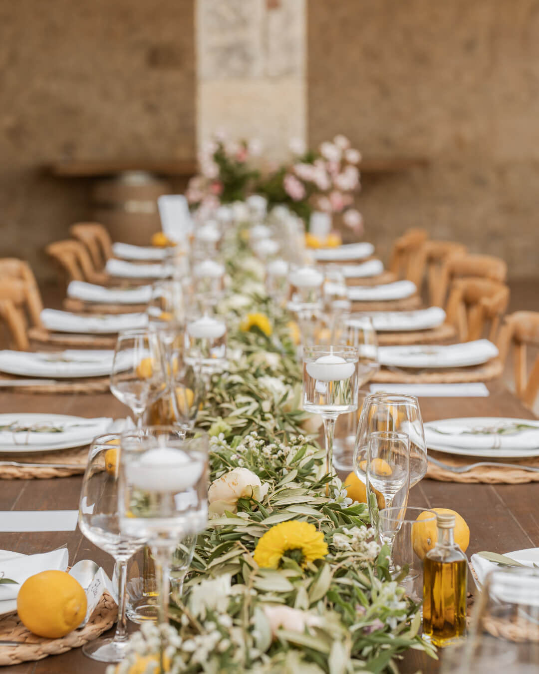 Longue tablée dressée aux citrons, olivier et fleurs pour le dîner